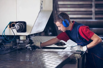 worker aligning metal sheets